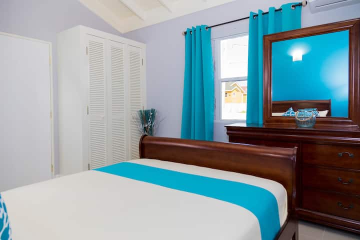 Desde tu cama tamaño queen, mira por la ventana y disfruta del paisaje del patio trasero. Un gran espejo perfecto para prepararse para un día en la playa o una noche en la ciudad. El dormitorio con aire acondicionado también cuenta con ventilador de techo para mayor comodidad