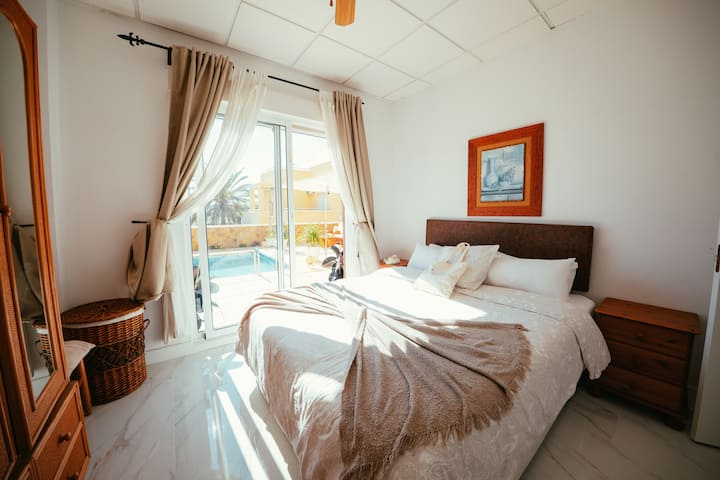 Camera da letto con letto da 160 cm con accesso diretto alla piscina e vista sull'oceano