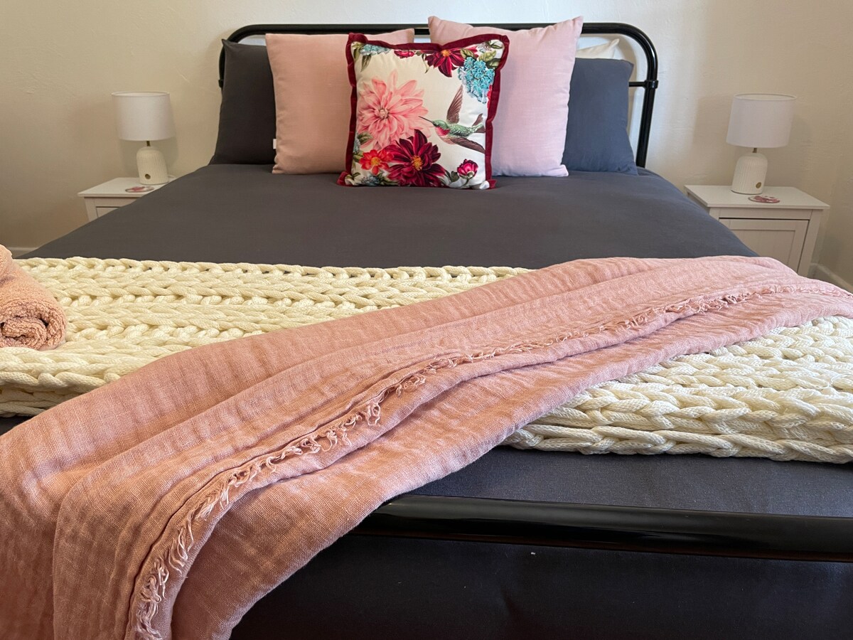 Bedroom 1, has a Queen Sized Bed, two bedside touch lamps and additional power/USB ports on either side of the bed. There is also a wardrobe to hang your clothes and a chair for your use in the room. 