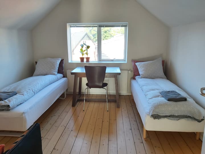 第二间卧室配备2张单人床、1张书桌和1张双人沙发。