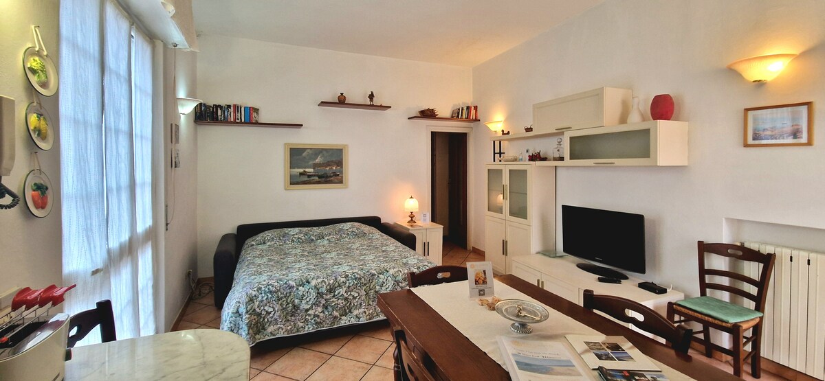 Sala de estar de la casa más grande en la segunda planta equipada con una mesa que se puede acomodar y, por lo tanto, adecuada para 7 personas. Este entorno puede convertirse en un dormitorio adicional gracias al sofá cama. También incluye una cocina de mármol blanco y un balcón. 