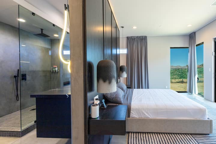 Rummelig primær suite med kingsize-dobbeltseng, regn-/håndbruser, naturligt lys og panoramaudsigt.