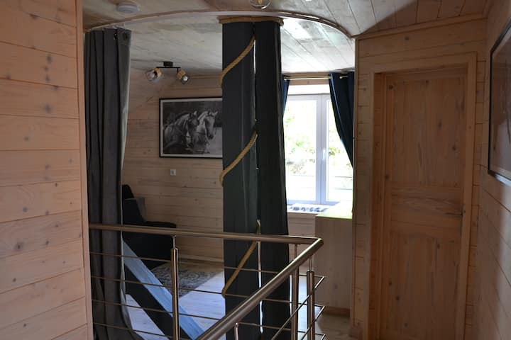 Upstairs, a small mezzanine living room open to the landing, with a bedroom area (140 cm sofa bed) that can be separated by curtains. On the right, the bathroom, and behind, the 4 bedrooms.