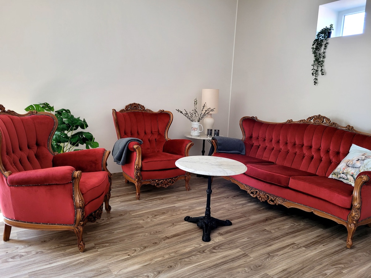 La zona de estar antigua está completamente revestida y abastecida para una cómoda sesión. Aquí puedes ver la televisión o disfrutar de un folleto, con vistas al resto de la habitación.