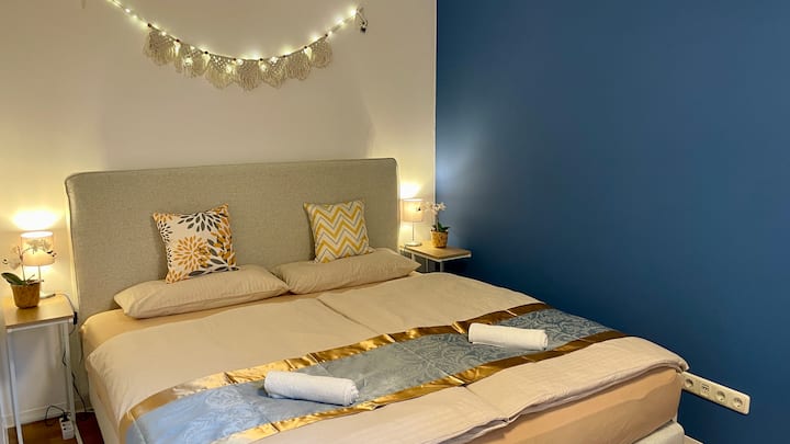 Кревет со пружина во кутија со големина од 1,80 x 2,00м. Паметен телевизор и ламби покрај креветот со приклучоци