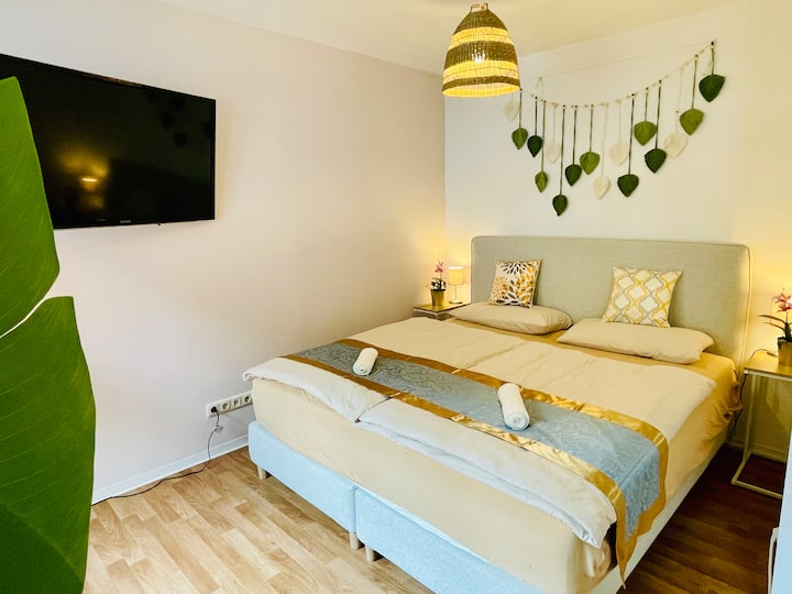 Кревет со пружина во кутија со големина од 1,80 x 2,00м. Паметен телевизор и ламби покрај креветот со приклучоци