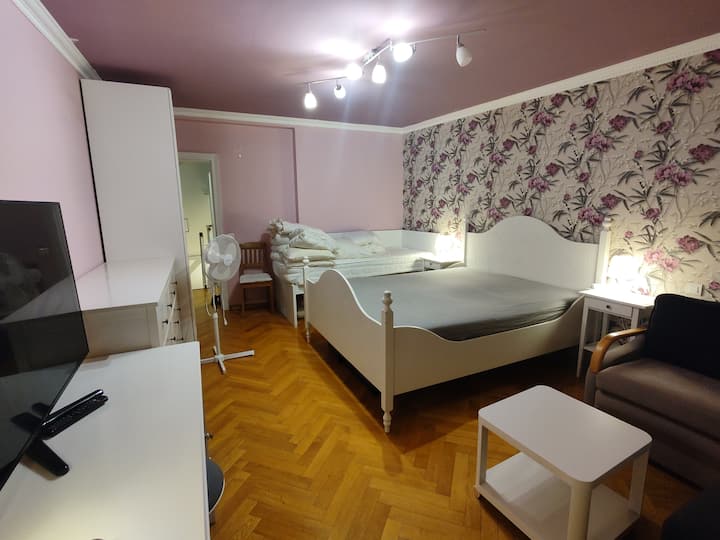 ห้องนอน 1 พร้อมเตียงควีนไซส์เตียงเดี่ยวเตียงโซฟาทีวีขนาดใหญ่ตู้เสื้อผ้าและระเบียง