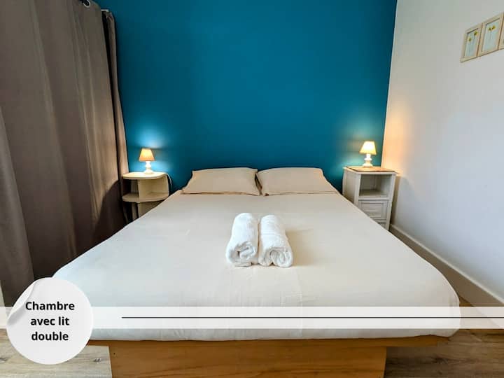 Chambre lumineuse avec lit double et mur coloré pour une touche moderne.