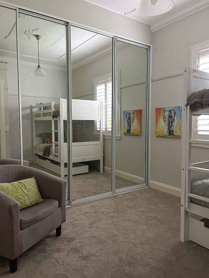 Literas para amigos o niños en una habitación grande. La cama inferior tiene un colchón con muelles y el colchón superior es de espuma. Silla de lectura o enfermería.