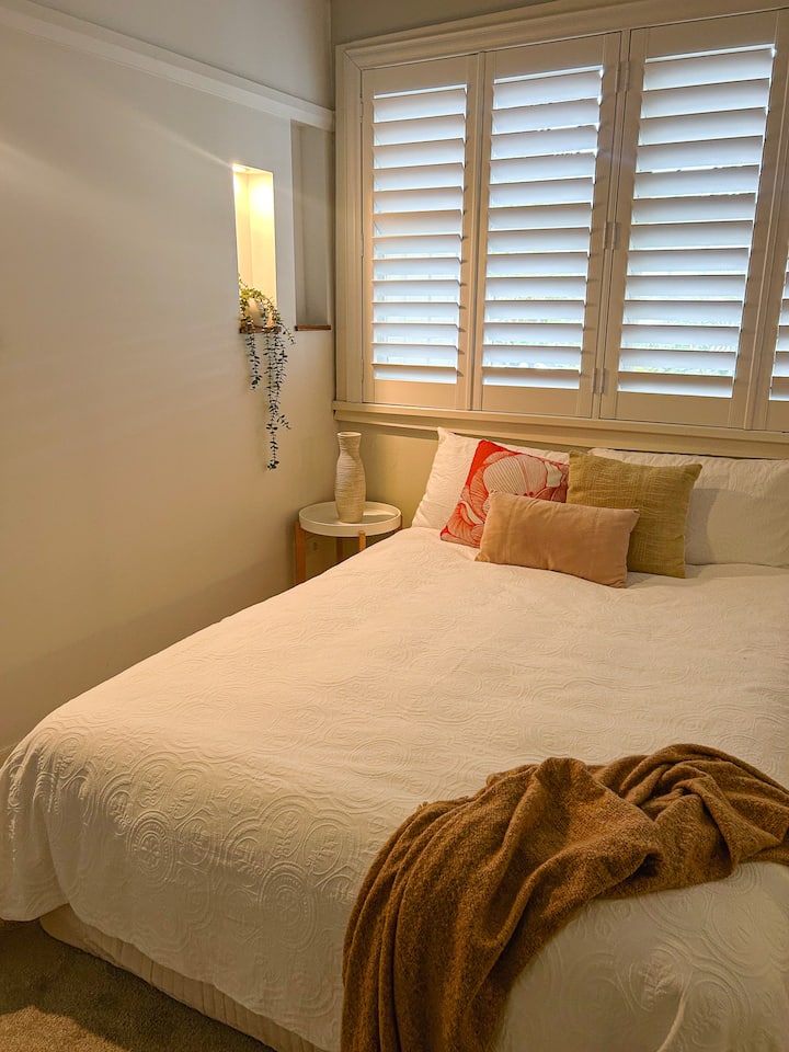 Cómoda cama doble con estanterías y luces y armario con espejos de pared a pared.