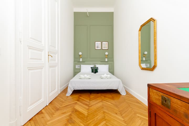 Cómoda cama doble en el primer dormitorio que está elegantemente equipada con todo para un buen descanso nocturno