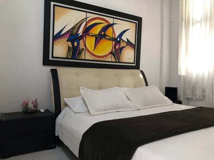 De hoofdslaapkamer heeft een tweepersoonsbed, een kast en airconditioning. 