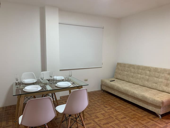 Relaksohu në divanin e rehatshëm ngjyrë bezhë në dyshemenë e ngrohtë. Shijo televizorin me ekran të sheshtë dhe kontrollo dritën me të verbrin e bardhë. Hapësirë e thjeshtë dhe praktike me mure të pastra. Pushimi yt i përkryer në Loja!