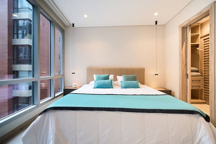 Habitacion confortable con ventana lateral, cama king, baño de lujo con walking closet.