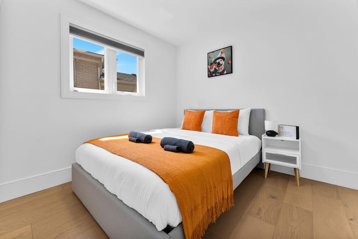 Slnečná spálňa s manželskou posteľou Queen s odvážnymi oranžovými prvkami

