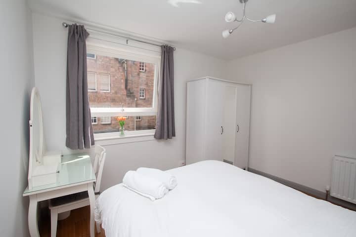 Double bedroom with dressing table and large cupboard.