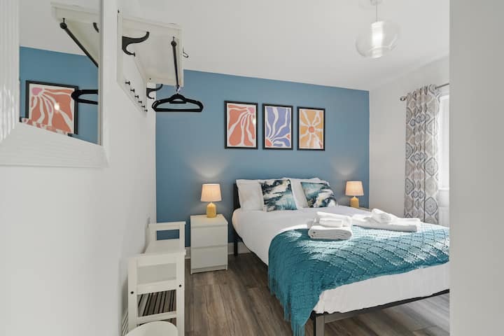 Relájate en un entorno tranquilo y sereno: este dormitorio con detalles en turquesa está diseñado para la relajación, con colores relajantes, iluminación suave y una cama cómoda que facilita el apagado y la recarga.