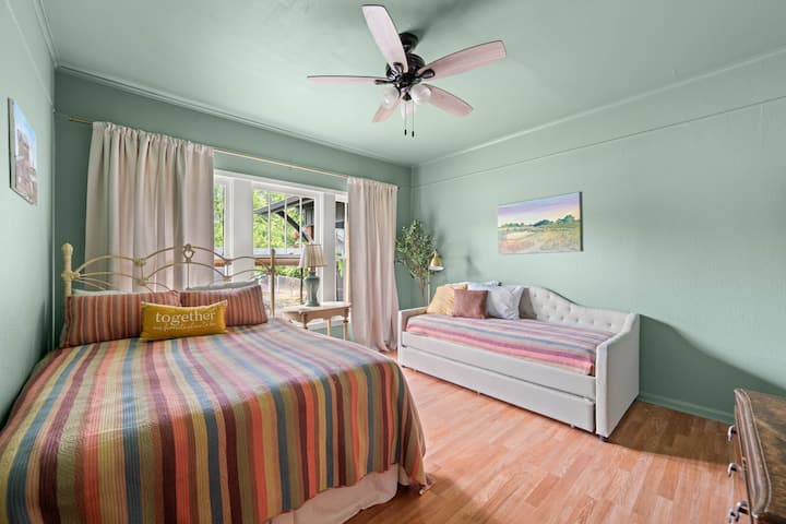 This room sleeps four, with a queen size and two twin beds with extra bedding and pillows in the closet, ceiling fan, tv with Netflix, drawers and closet with hangers for storage.