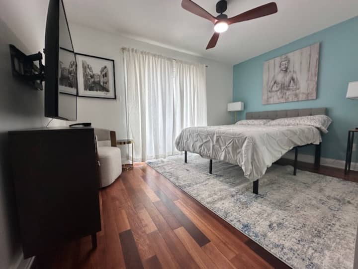 ¡Cómoda cama tamaño queen con almohadas mullidas, sábanas suaves y un televisor grande para noches relajantes!