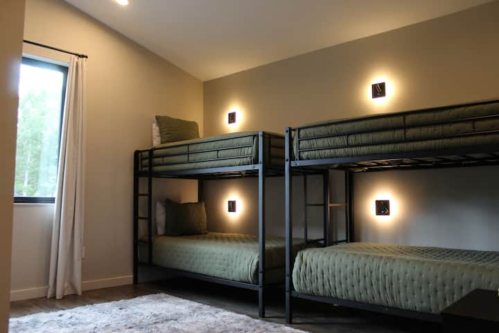 Two sets of bunk beds (four twin beds) enveloped in a cozy ambiance. Enjoy the built-in lamps and charging ports, a smart TV for your entertainment and a built-in desk that provides a perfect workspace for those planning to work during their stay.