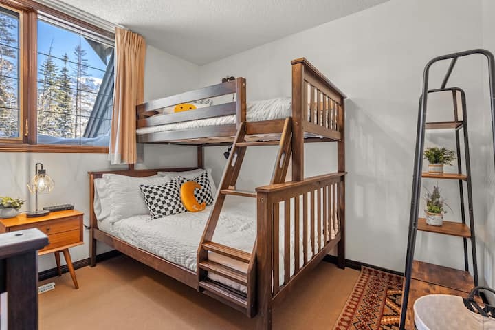 תיהנו משהייה מרעננת בחדר השינה הראשון. בחדר הזה יש 2 מיטות קומתיים עם מצעים, כריות רכות ושידה ליד המיטה עם מנורה.