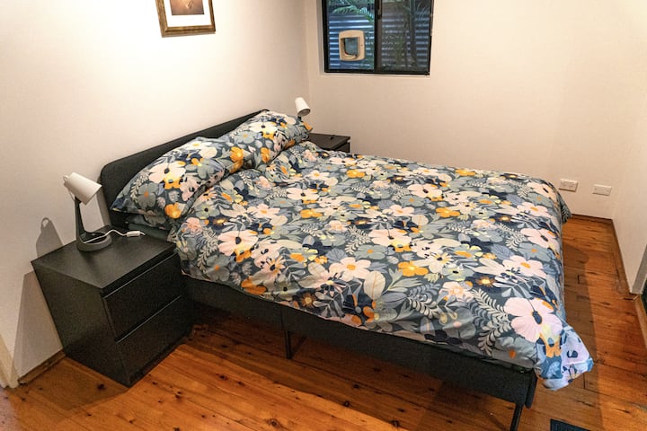 Queen size bed with bedside tables and lamps, USB point in corner