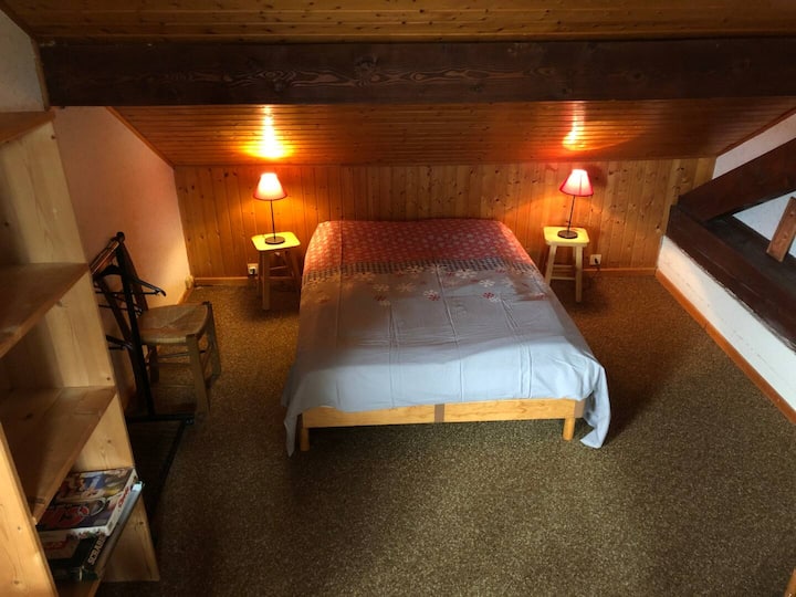 Séparé du salon par un rideau, un coin couchage avec lit double