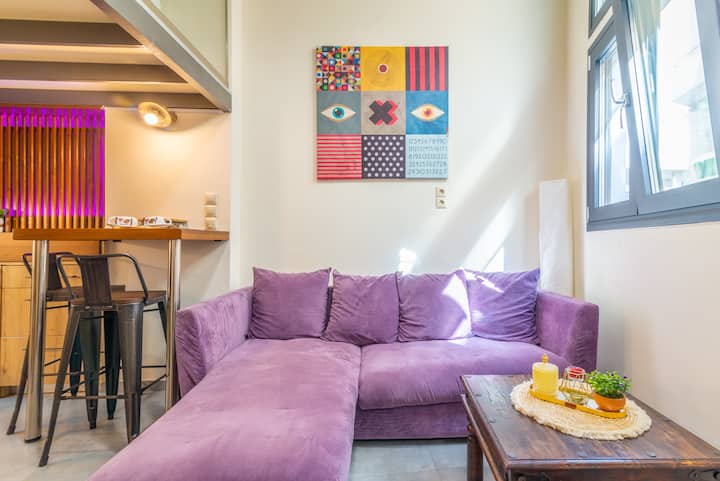 Уште еден поглед на каучот од лаванда, кој ја покажува неговата пространост и малата масичка за кафе, идеална за опуштање по разгледувањето на градот.