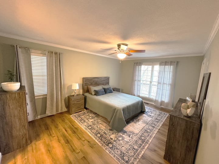 Chumba cha kulala cha msingi cha ghorofa ya juu kina kitanda cha malkia chenye starehe, bafu lenye bafu la kuingia, vyombo vya mapambo kwa ajili ya kuhifadhi nguo na madirisha makubwa yanayoonyesha mandhari nzuri ya ziwa, na kuifanya iwe sehemu nzuri ya kumaliza siku.

