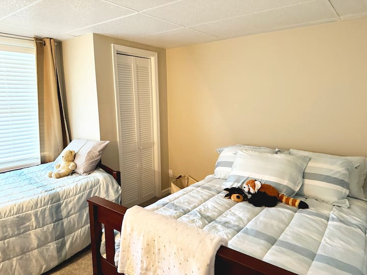 Chumba cha kulala cha ghorofa ya chini ni kizuri kwa watoto, kikiwa na kitanda pacha na cha ukubwa kamili kwa ajili ya ukaaji wa starehe. Iko nje kidogo ya sebule ya ghorofa ya chini, ni chumba tulivu zaidi ndani ya nyumba.