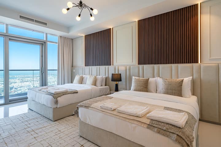 El dormitorio doble queen ofrece una impresionante ventana del piso al techo con increíbles vistas al horizonte de la ciudad.