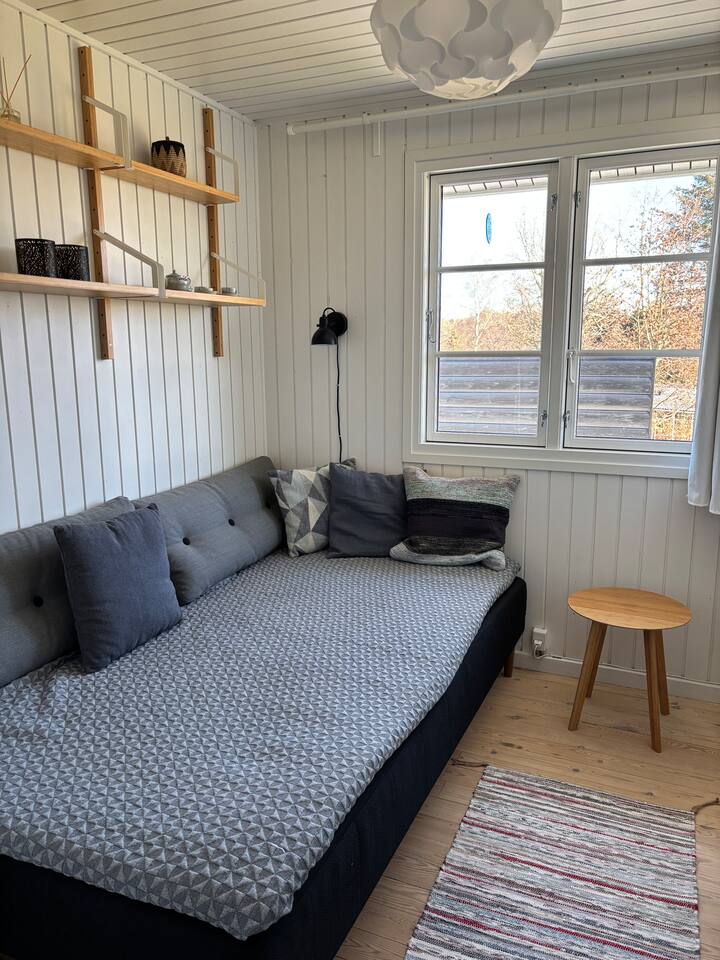 Პატარა ორადგილიანი საწოლი 120 სმ, რომელიც აღჭურვილია გარდერობითა და საკიდებით