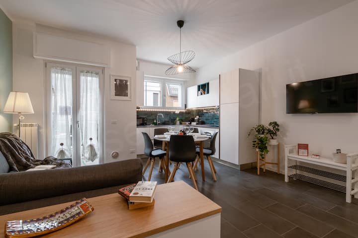 Muhtasari wa sebule angavu, yenye kitanda cha sofa mbili, eneo la kulia chakula lenye jiko kamili na televisheni.