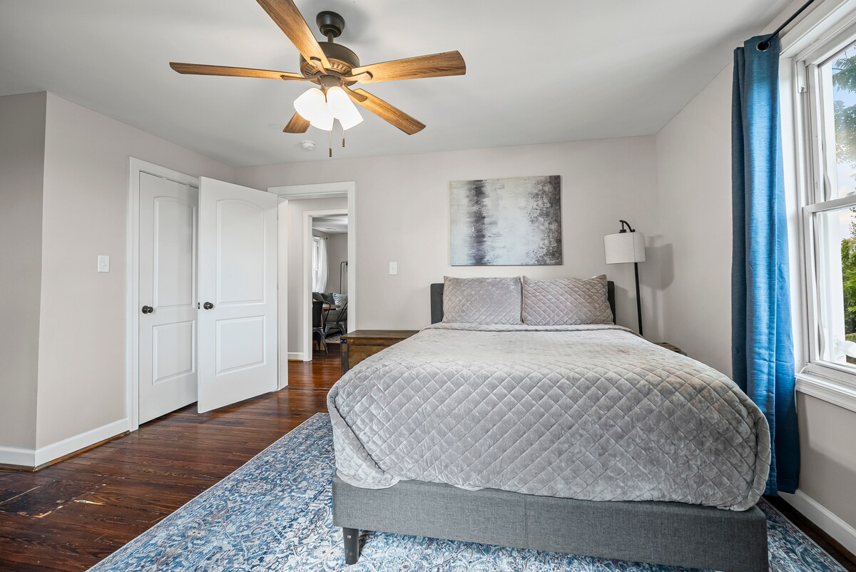 Dormitorio 2: cama tamaño queen, cortinas opacas, ventilador de techo, armario, cómoda, mesitas de noche, portaequipajes y sillón.