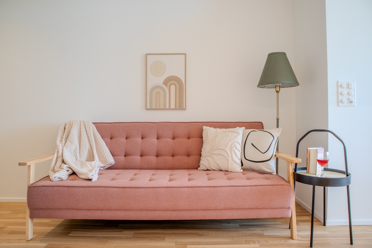 סלון מואר עם ספה מודרנית, אביזרים דקורטיביים ותאורה נעימה. אידיאלי למנוחה אחרי יום במפלי הריין.