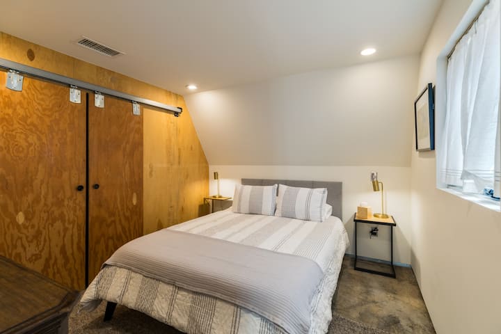 Charming Bedroom Retreat: Relax in a stylish space with unique barn doors and natural light!