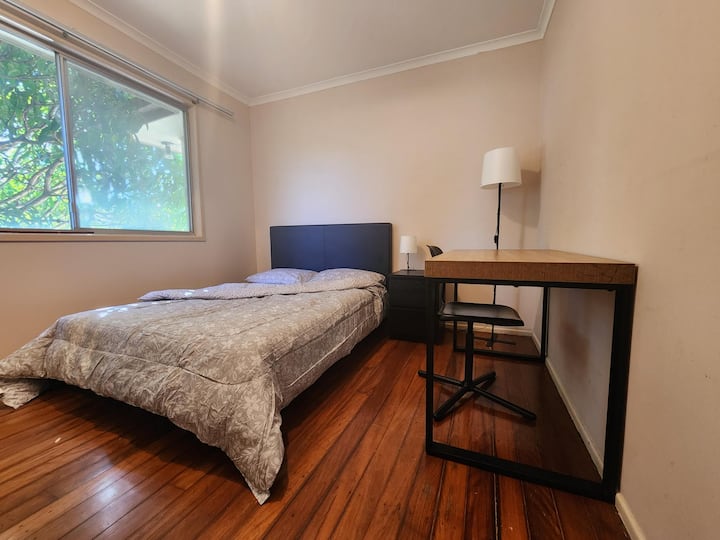 Chumba cha kulala cha kujitegemea kilicho na kitanda cha watu wawili, dawati, kiti na kabati la nguo lililojengwa ndani ya nyumba ya pamoja