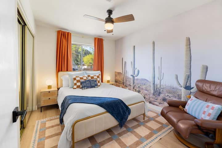 Dormitorio 2 con mural de cactus y silla de cuero