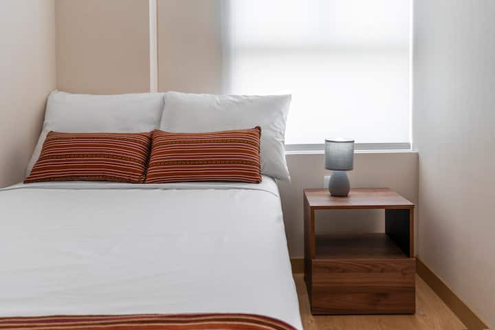 Veilleuse moderne et lit avec draps en fils