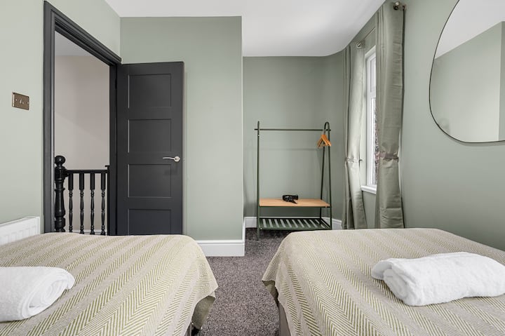 舒适的双人卧室，配备两张单人床、柔软的床上用品和自然光，非常适合朋友或家人共用空间。