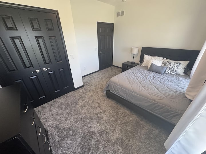 这张照片很好地展示了 2 号卧室的空间。 标准双人床、床头柜、带USB端口的灯、吊扇、梳妆台、2扇窗户和一个大衣柜。