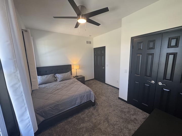 3号卧室，展示了它有多宽敞。 标准双人床、吊扇、床头柜、带USB端口的灯和衣柜区域的门。