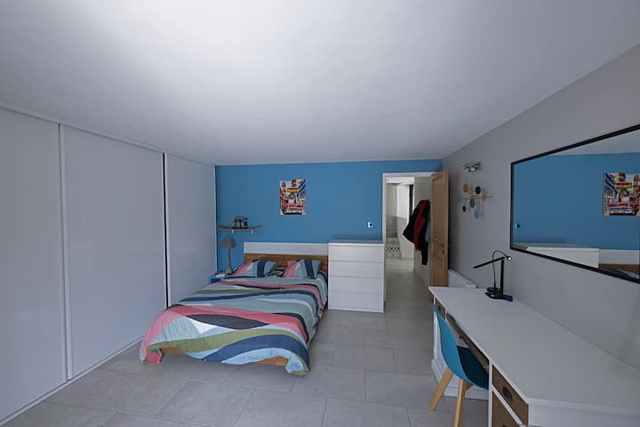 Spavaća soba s bračnim krevetom od 23 m2 s radnim stolom i izlazom na stražnju terasu.
