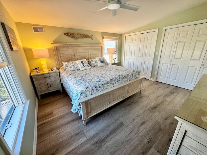 Დიდი მეორე სართულის მთავარი საძინებელი დიდი საწოლით სანაპირო დეკორით.  Თითოეული ღამის სადგამი მოიცავს მაღვიძარას მარტივი წვდომის საშუალებებით, ასევე, USB ‑ A და USB ‑ C პორტებს მოსახერხებელი დამუხტვისთვის