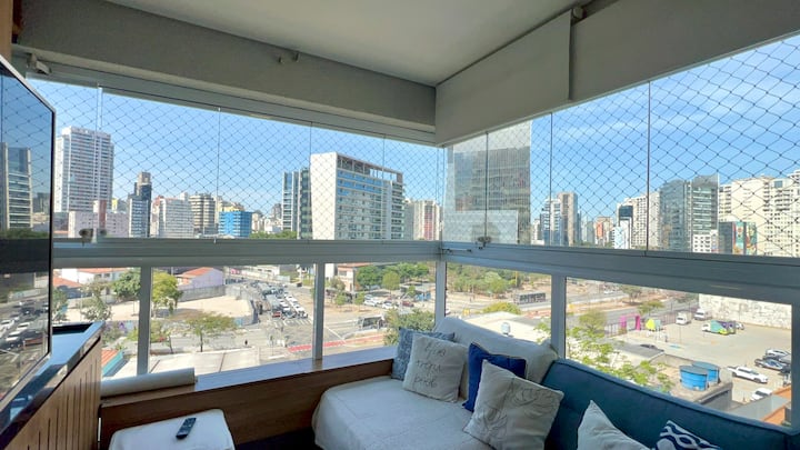Vista da sala de estar para a Avenida Faria Lima, com janelas de vidro antirruído que oferecem conforto e tranquilidade no coração de Pinheiros.