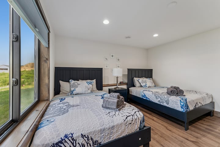 ห้องนอนที่ 5 มีเตียงเต็มขนาด 2 เตียง โต๊ะข้างเตียงและโคมไฟ ตู้เสื้อผ้าพร้อมไม้แขวนเสื้อ