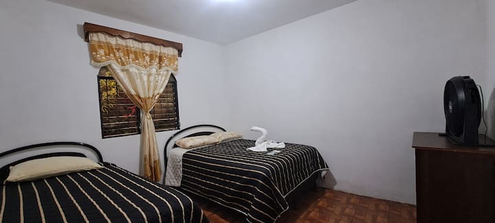 Удобна соба опремена со два кревета, идеална за семејства, парови или пријатели кои сакаат да ја делат. Вентилатор за дополнителна удобност. Прозорец со завеси кој овозможува добро природно осветлување во текот на денот за вашиот престој да биде посебен.