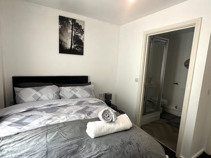 El acogedor dormitorio cuenta con una cómoda cama tamaño queen, muebles elegantes y su propio baño privado para mayor comodidad y privacidad. Perfecto para una estadía relajante.