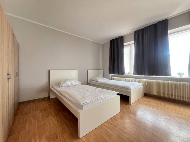 חדר זוגי עם שתי מיטות יחיד (90x200 ס"מ). כולל מצעים וכיסויים. לכל חדר שינה יש שולחן עבודה, ארון בגדים, טלוויזיה ומיני מקרר משלו.