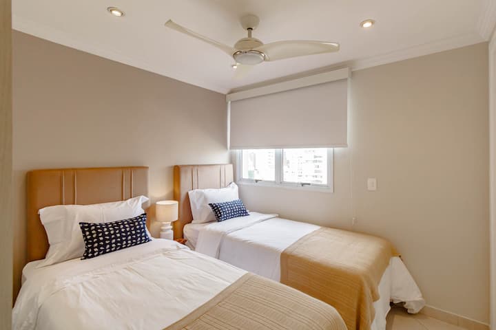 Deuxième chambre avec deux lits simples et décoration dans des tons neutres